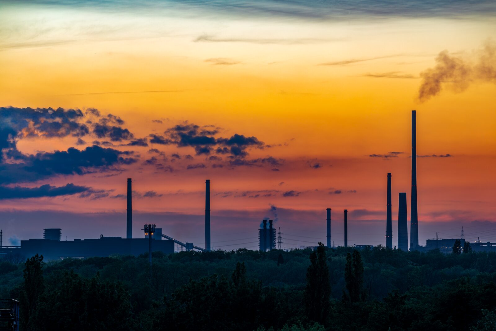 Industrial plant at dusk with stacks and structural steel — the kind of infrastructure commercial drone inspection programs document