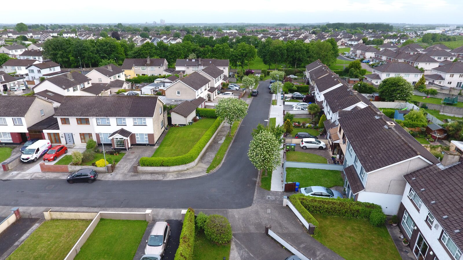 Aerial view of a residential street and homes — representative deliverable for real-estate aerial media shoots